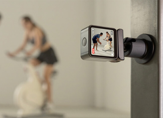 壁に取り付けられたカメラでジムトレーニングする女性を撮影する様子
